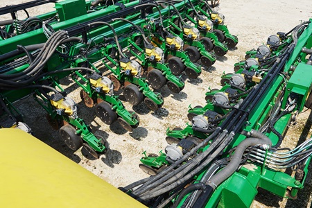 Close up of seeder attached to tractor in field. Agricultural machinery for spring works sowing